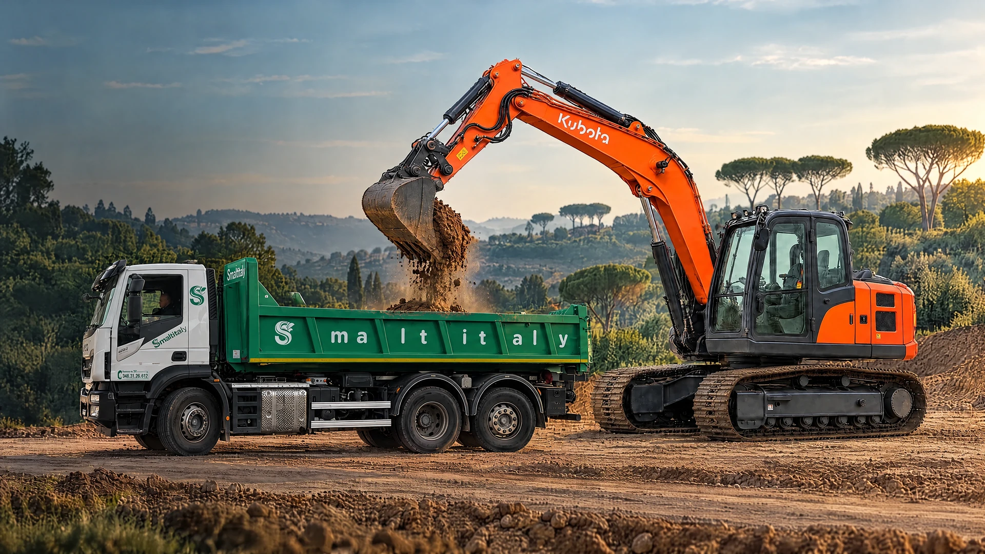 Scena illustrativa: escavatore Kubota che carica la terra nel cassone di un camion Iveco Smaltitaly a tre assi con cassone verde, entrambi appoggiati sulla strada di cantiere